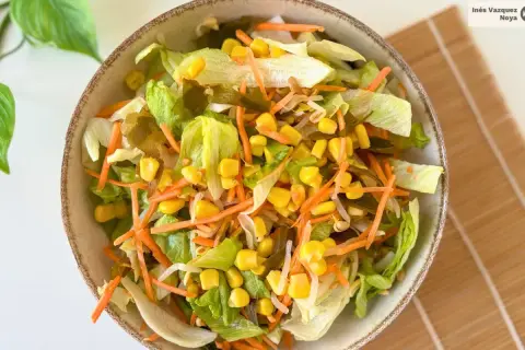 Ensalada china fresca con lechuga, zanahoria rallada, maíz y brotes.