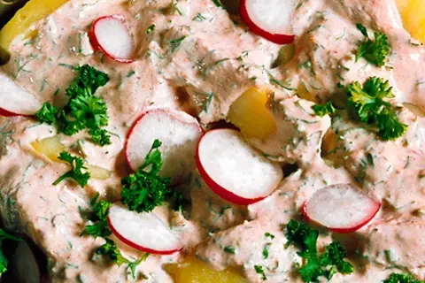 En krämig potatissallad med skivade rädisor och färska örter. Den här ser ut att vara den godaste potatissalladen någonsin!