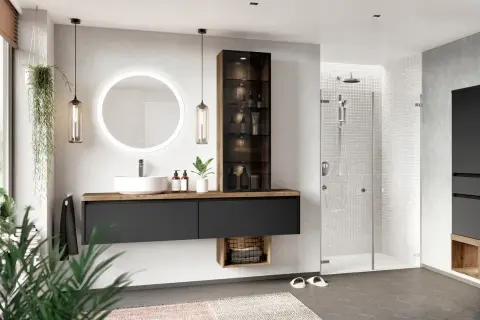 Ein modernes, zeitloses Badezimmer mit Waschtisch, beleuchtetem Spiegel, Duschkabine und Pflanzen.