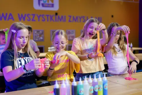 Dzieci tworzą slime, świetne atrakcje na Dzień Dziecka. Radość i kreatywność w kolorowym świecie zabawy.