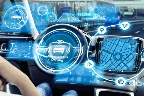 Wnętrze samochodu z zaawansowanym interfejsem pokazującym dane o ruchu, nawigację i status "Autonomous Driving".