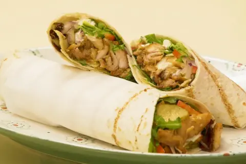 Pyszny domowy kebab w tortilli z soczystym mięsem, świeżymi warzywami i kremowym sosem. Idealny na szybki posiłek.