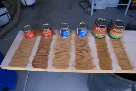 General Finishes stain color chart showing Pecan, Antique Cherry, Americano, Nutmeg, Light Brown, and Pecan wood stain samples on oak.