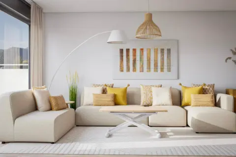 Sofá modular beige con cojines amarillos y blancos, mesa de centro blanca, lámpara de pie y cuadro abstracto. Un espacio acogedor sin ruido visual.