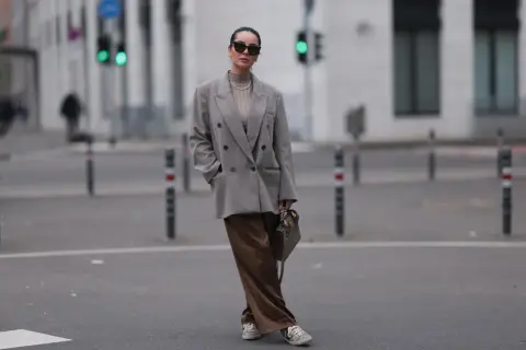 Grauer Oversize-Blazer und braune Satinhose: Perfekt, welche Jacke zu weiten Hosen passt. Modisch und bequem in der Stadt.