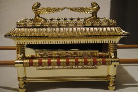 Réplica dorada del arca de la alianza, con querubines alados en la tapa y detalles ornamentales.