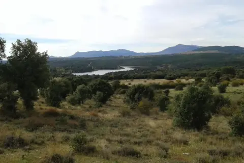 Paisaje con embalse y montañas al fondo, evocando la belleza de las paredes de Buitrago.