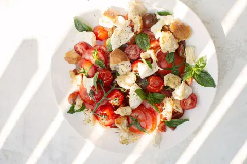 Tomate Mozzarella Salat mit geröstetem Brot und Basilikum, ein sommerlicher Genuss.