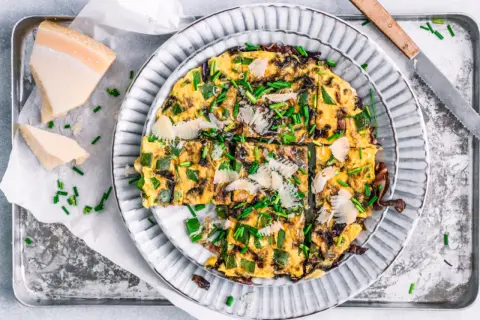 Herzhafte Frittata mit Paprika, Zwiebeln und Parmesan, garniert mit Schnittlauch. Perfekt für schnelle 15 Minuten Rezepte.