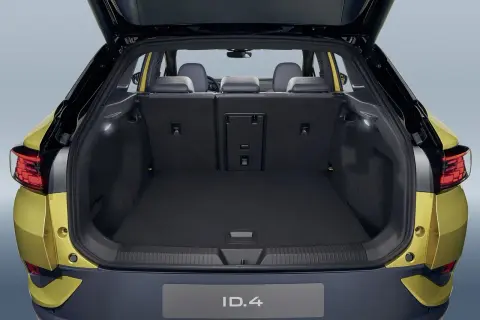 Vue du coffre ouvert d'une Volkswagen ID.4 jaune. Le volume du coffre est spacieux, prêt à accueillir vos bagages pour un long voyage.