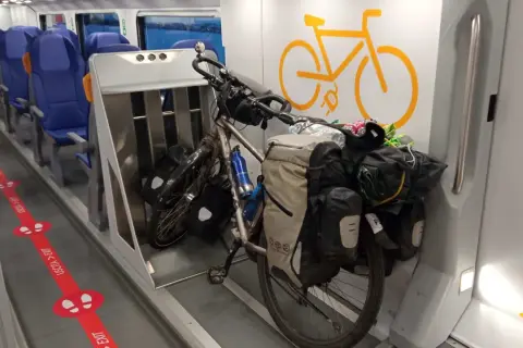 Rower w pociągu, gotowy na przygodę. Wygodne siedzenia i miejsce dla pasażerów z bagażem.
