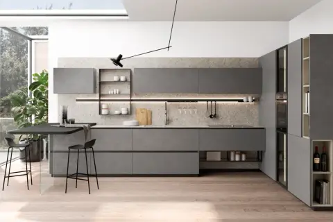 Plan cuisine en L moderne, gris, avec îlot, tabourets et grandes fenêtres.