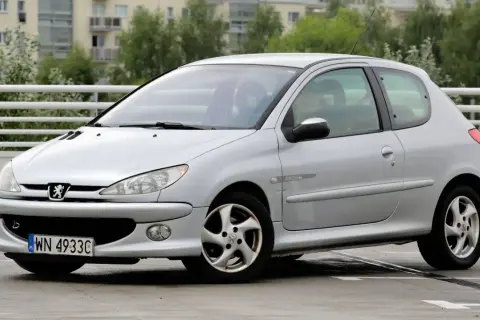 Srebrny Peugeot 206 1.4 benzyna z polskimi tablicami rejestracyjnymi na parkingu.