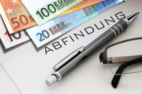 Euro-Scheine liegen auf einem Dokument mit dem Wort "ABFINDUNG". Ein Stift und eine Brille deuten auf eine bevorstehende Entscheidung oder Vereinbarung hin, vielleicht eine Abfindung nach 4 Jahren.