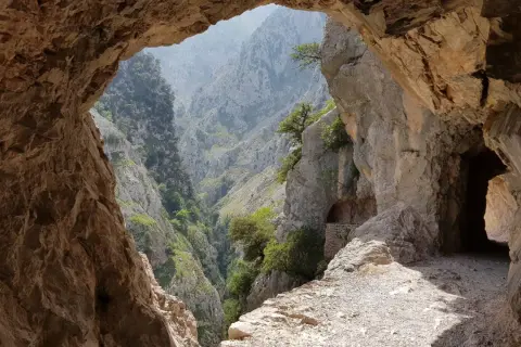 Vista desde una cueva de un desfiladero verde y rocoso, parte de la ruta de la reconquista.