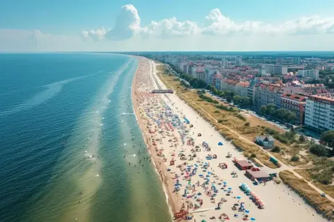 Słoneczna plaza Stogi tętni życiem. Tłumy plażowiczów, kolorowe parasole i błękitne morze tworzą wakacyjny obraz.