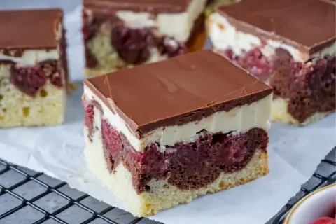 Saftiger Schneewittchenkuchen vom Blech mit Kirschen, Schokoglasur und cremiger Schicht. Ein Genuss für jeden Anlass!