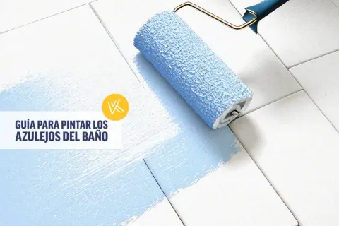 Rodillo azul pintando azulejos blancos, transformando un baño antiguo. Guía para pintar azulejos.