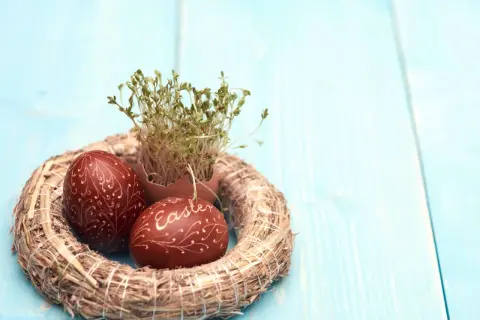 Wianek z rzeżuchą i pisankami, jedna z nich ozdobiona napisem "Easter".