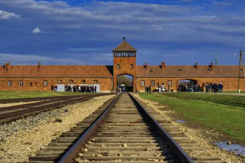 Brama obozowa Auschwitz, tory kolejowe prowadzące do niej. Informacje o auschwitz bilety cennik.