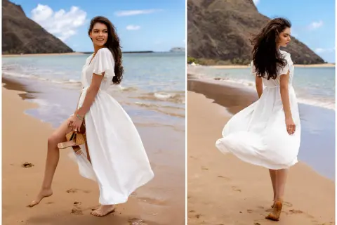 Kobieta w zwiewnej, białej sukience spaceruje po plaży. Idealne biała sukienka stylizacje na wakacje.