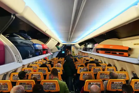 Wnętrze samolotu Ryanair, bagaże na półkach. Gdzie znajdę numer lotu Ryanair? Na ekranach przed siedzeniami.
