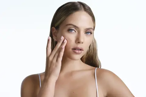 Frau trägt ein Serum auf, das die Haut mit Feuchtigkeit versorgt, um zu verhindern, dass Retinol die Haut austrocknet.