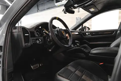 Luksusowe detailing wnętrza Porsche: skórzana kierownica, sportowe fotele z alcantary i nowoczesna deska rozdzielcza.