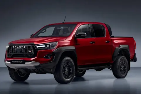 Czerwony Toyota Hilux GR Sport z czarnymi dodatkami i felgami, gotowy na każdą przygodę.
