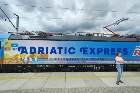 Kobieta na tle lokomotywy "Adriatic Express", która zabierze ją pociągiem do Chorwacji.