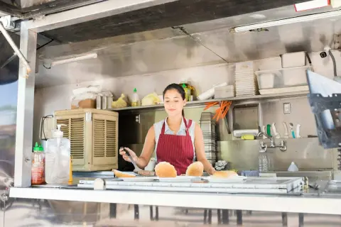 Donna prepara panini nel suo food truck, un sogno che sta per aprire.