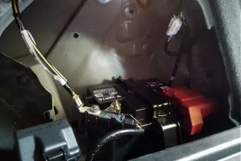 Akumulator w Toyocie CHR znajduje się w bagażniku, po prawej stronie. Widać go na zdjęciu, pod czarną osłoną.