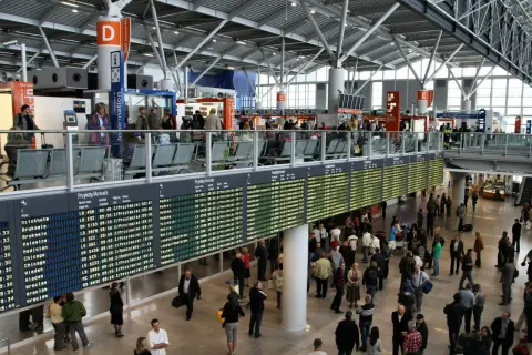 Lotnisko Chopina: tablice pokazują opóźnienia odlotów. Pasażerowie czekają na informacje.