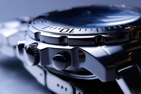 Reloj de pulsera con caja y brazalete de acero inox. Detalle de la corona y pulsadores.