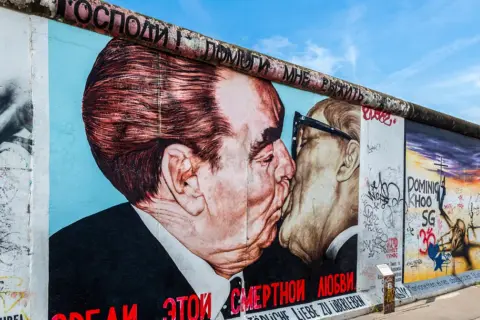 Słynny pocałunek Breżniewa i Honeckera na pozostałościach muru berlińskiego, symboliczny obraz wolności, gdy obalili mur berliński.