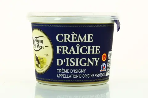 Un pot de crème fraîche d'Isigny, avec une vache dans un pré sur l'étiquette. La crème d'Isigny est une spécialité normande.