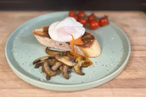 Un huevo poche perfecto sobre tostada con champiñones y tomates. ¡Así se hacen huevos poche deliciosos!