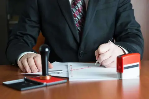 Notaio firma documenti, con timbro e inchiostro pronti per il deposito prezzo.