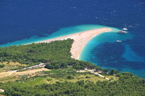 Zloty piasek i turkusowa woda na plaży w Chorwacji. Idealne miejsce na wakacje, pomyśl o bezpośrednie loty do chorwacji!