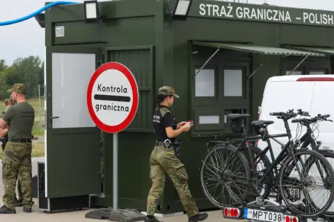 Strażnicy graniczni prowadzą kontrole na granicy niemieckiej. Obok zielonego punktu kontrolnego stoją dwa rowery na bagażniku samochodu.