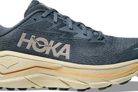 Chaussure de course Hoka bleu marine, avec semelle épaisse beige et détails orange. Le logo Hoka est bien visible. Parfaite pour le trail avec son drop 8mm.