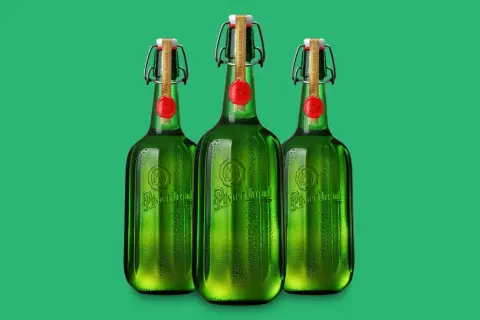 Drei grüne Flaschen Pilsner Urquell mit Bügelverschluss und rotem Siegel stehen nebeneinander.