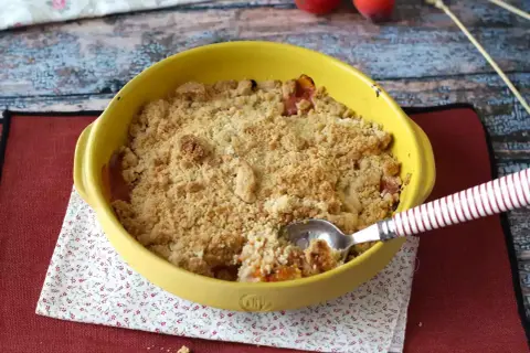 Ein goldbrauner Aprikosen Crumble in einer gelben Auflaufform, bereit zum Genießen.