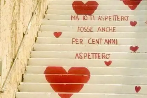 La scala dell'amore, con cuori rossi e la scritta "Ma io ti aspetterò, fosse anche per cent'anni, aspetterò".
