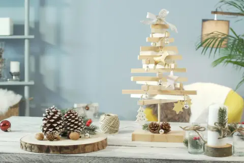 Un albero in legno fai da te, decorato con palline e renne dorate, crea un'atmosfera natalizia rustica.