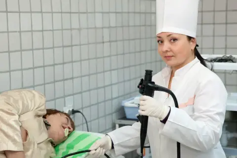 Lekarka przygotowuje się do gastroskopii. Pacjent leży na stole. Czy przed gastroskopią można brać leki? Zapytaj lekarza.
