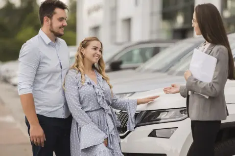 Para szybko sprzedać samochód, para rozmawia z doradcą w salonie samochodowym.