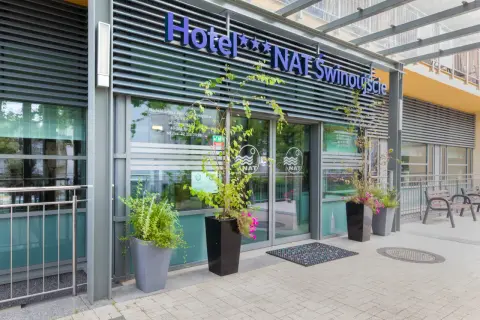 Nowoczesne hotele przy plaży w Świnoujściu, z zielenią i wygodnymi ławkami.