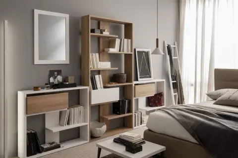 Moderna camera da letto con specchio, letto, e diverse piccole librerie piene di libri e oggetti decorativi.
