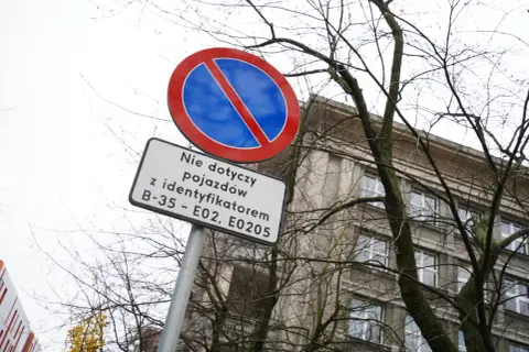 Znak zakazu parkowania z tabliczką informującą, że nie dotyczy pojazdów z identyfikatorami B-35 – E02, E0205.